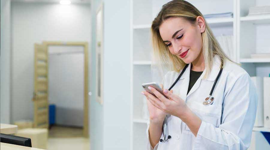 Female doctor texting on a cellphone.