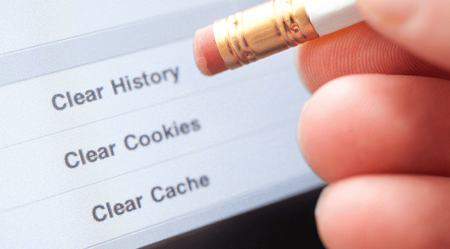 Finger holding pencil with eraser over screen reading clear history, clear cookies, clear cache